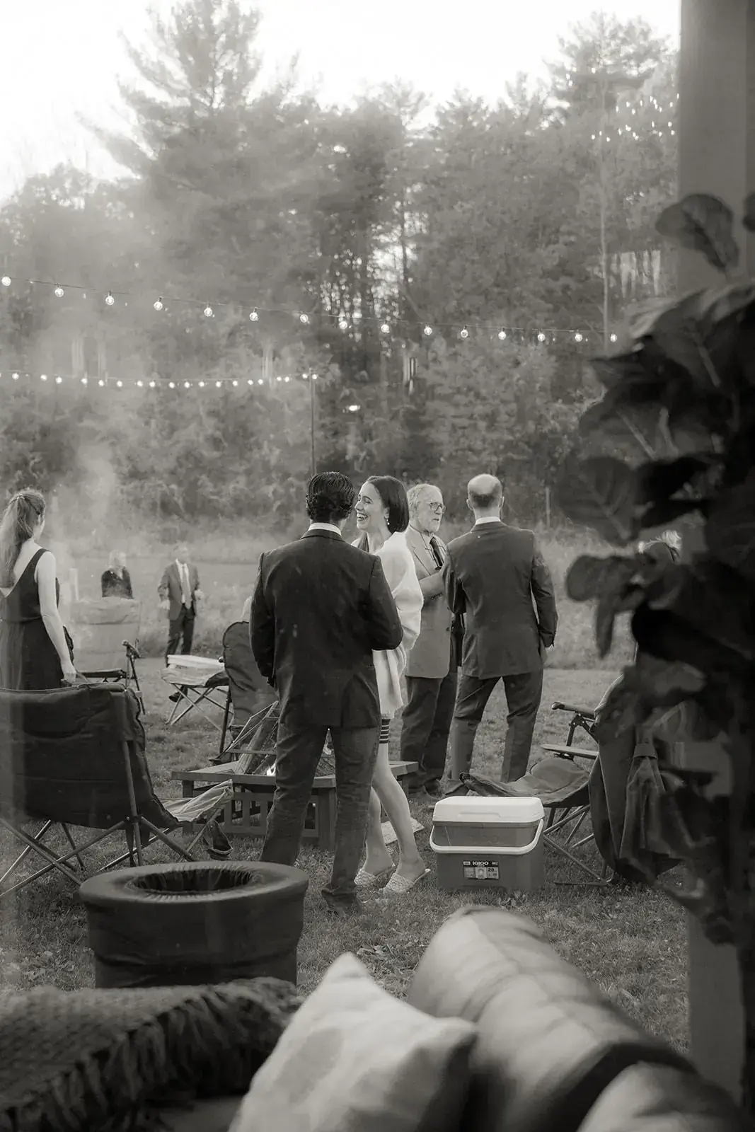 Guests around the firepit under string lights